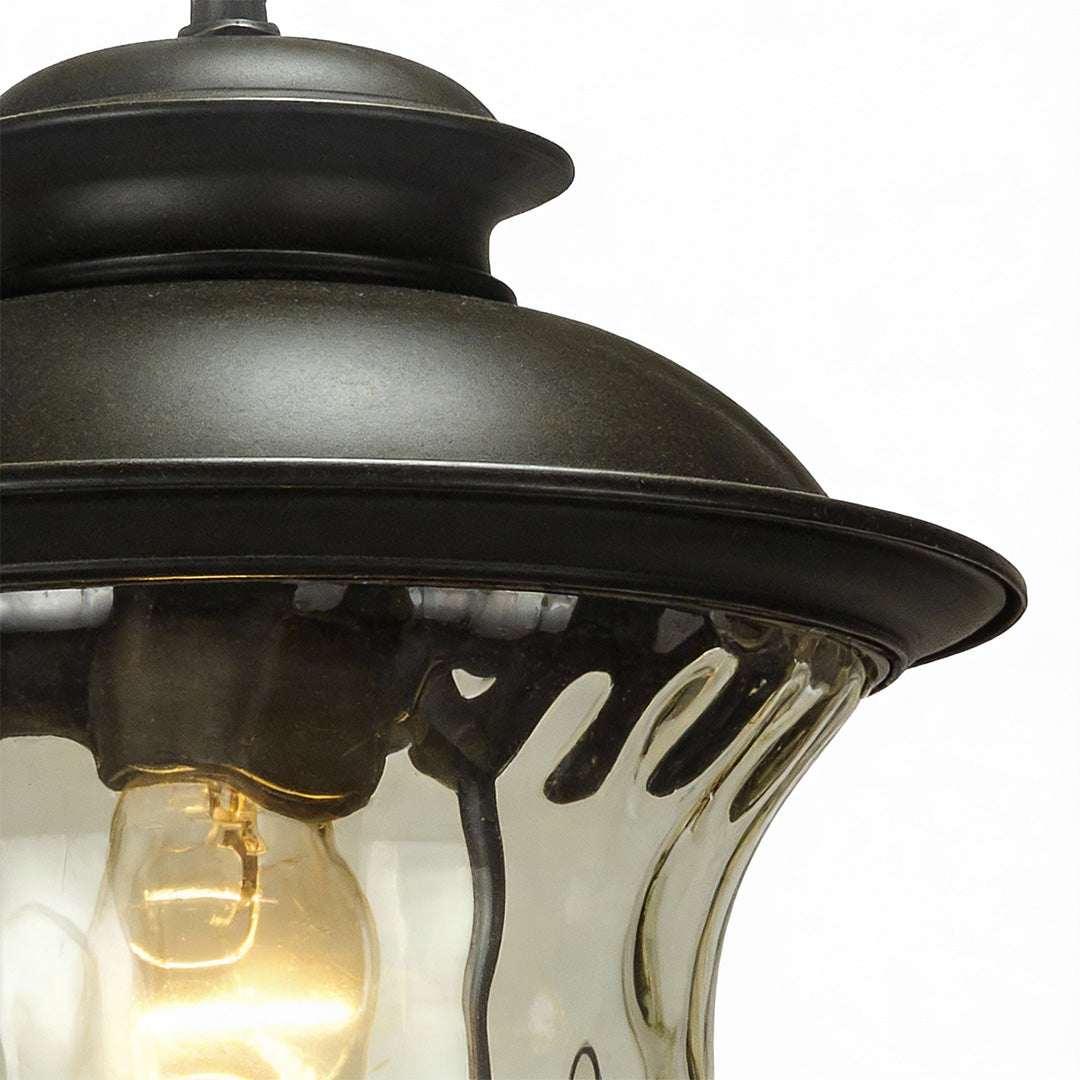 Rustic industrial metal pendant light with weathered bronze top and clear ribbed glass, ideal for vintage-inspired interior or covered outdoor spaces.