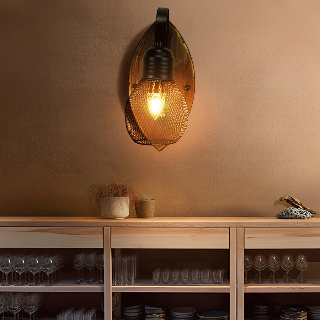 Rustic farmhouse wall sconce with warm Edison bulb lighting above a wooden cabinet.