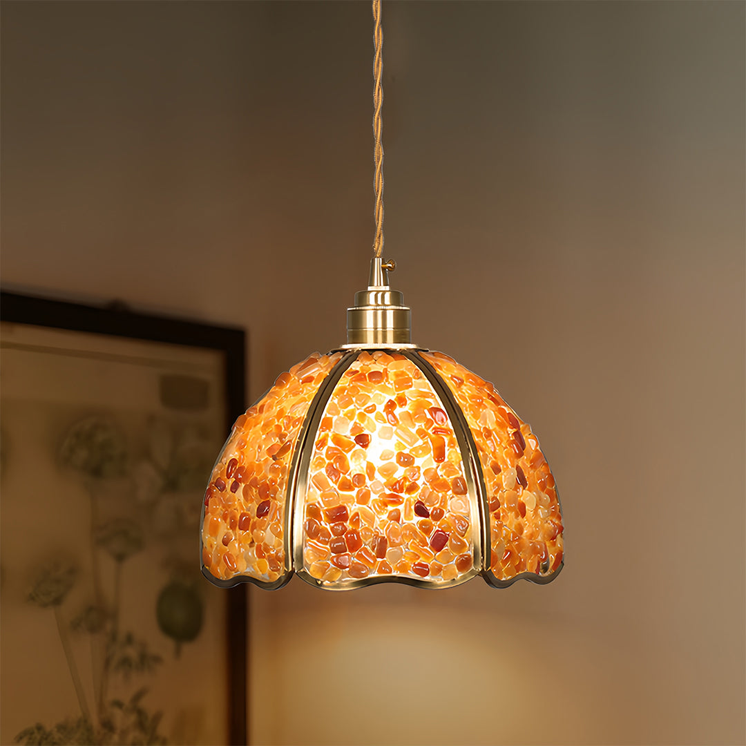 Orange crystal pendant light providing task lighting in rustic kitchen setting