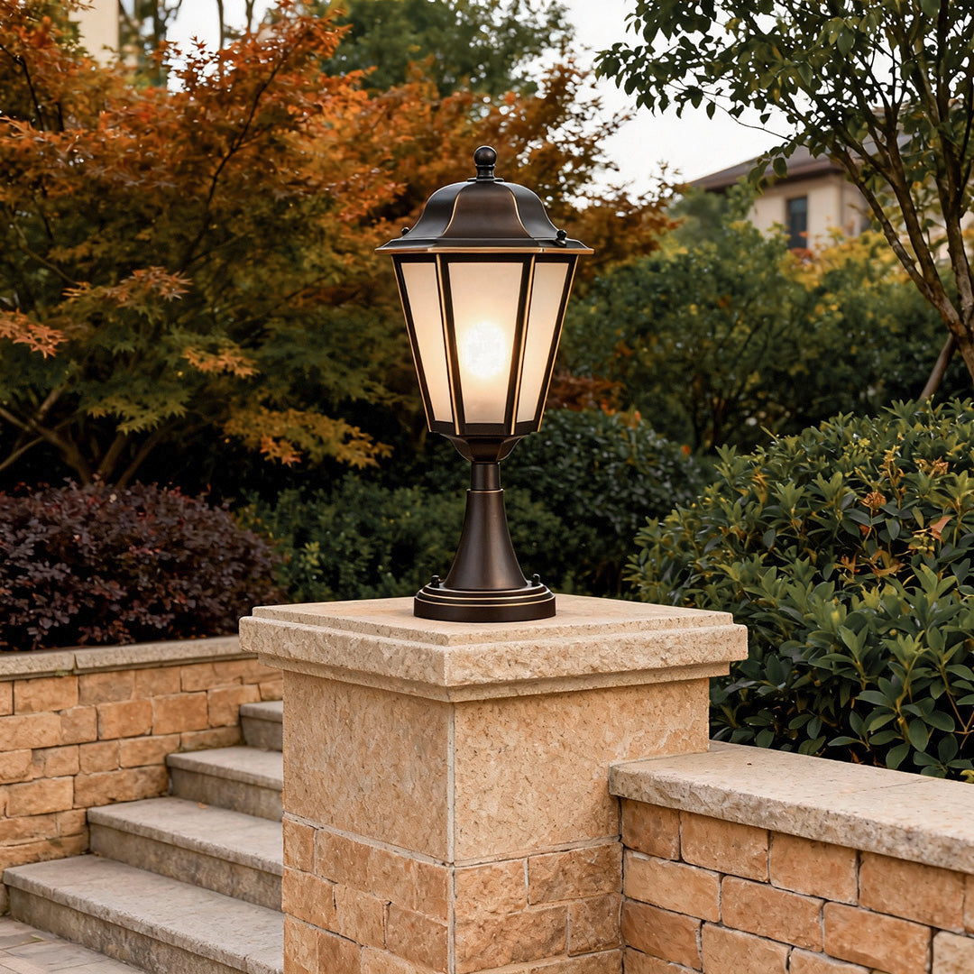 Rustic outdoor pillar light installed on stone wall with warm glow, perfect for garden or driveway ambiance.