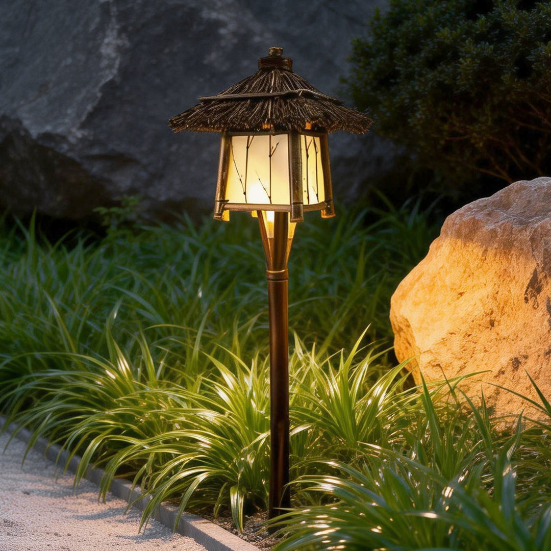 Rustic pendant light casting a gentle glow near a stone and plant landscape.