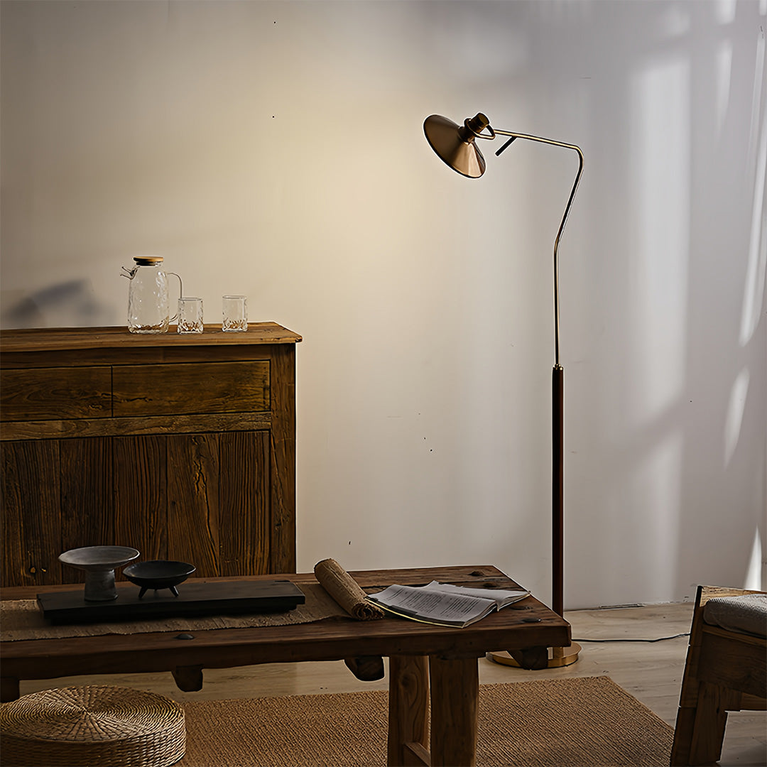 Rustic vintage gold floor lamp illuminating cozy reading corner with wooden desk and natural textures