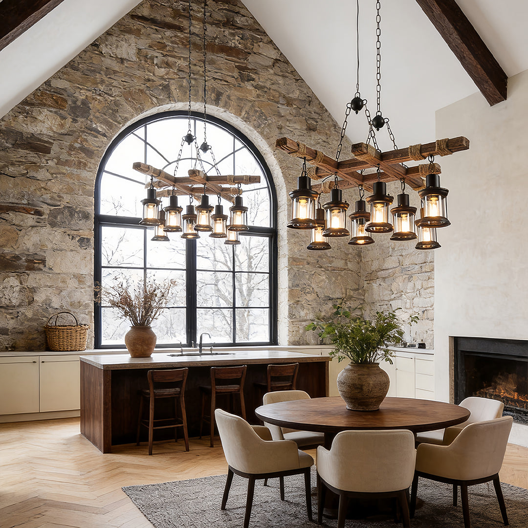 Rustic wood chandelier installed above dining table in stone wall farmhouse interior.