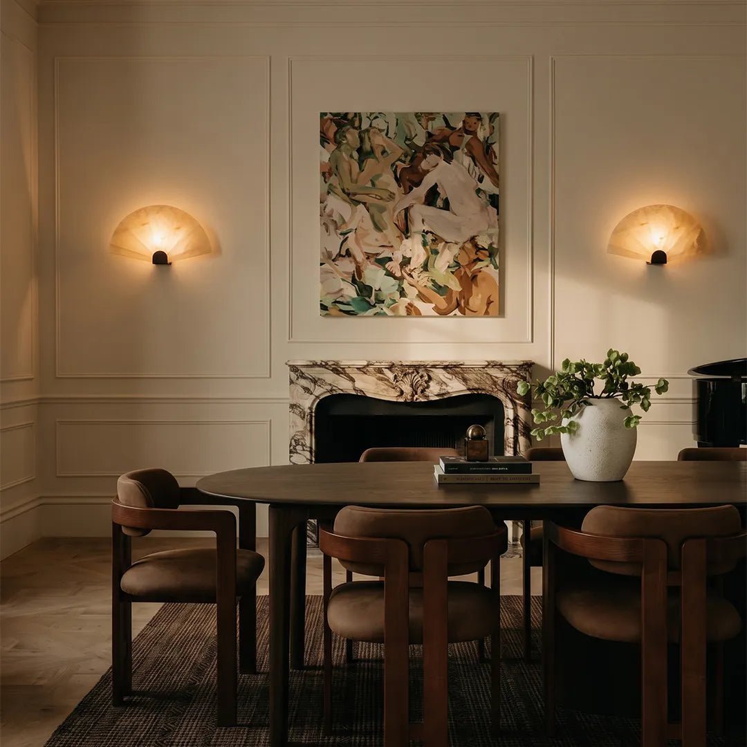 Scalloped wall sconce pair installed above a dining room sideboard with soft decorative lighting.