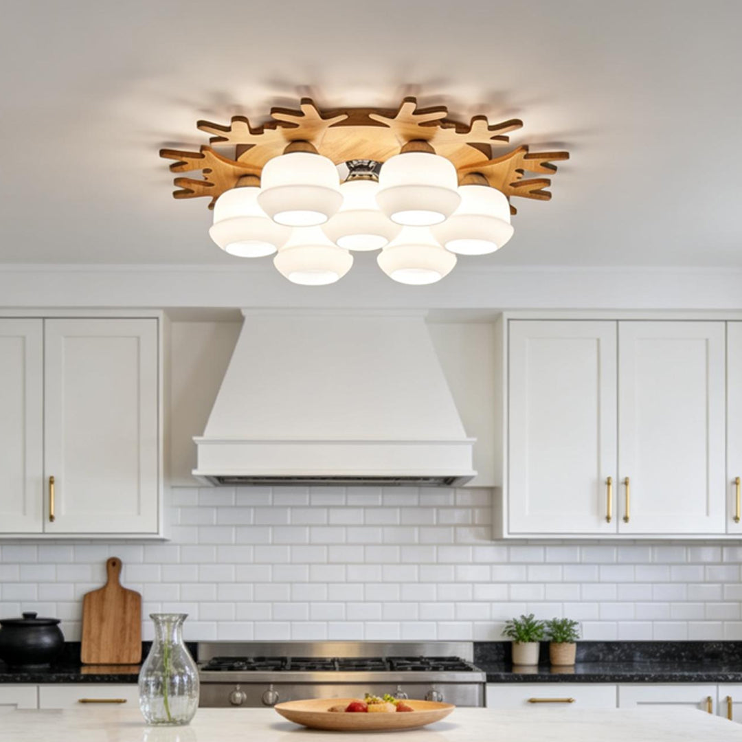 Scandinavian style globe ceiling lamp with wood frame and white glass shades installed in a modern kitchen.
