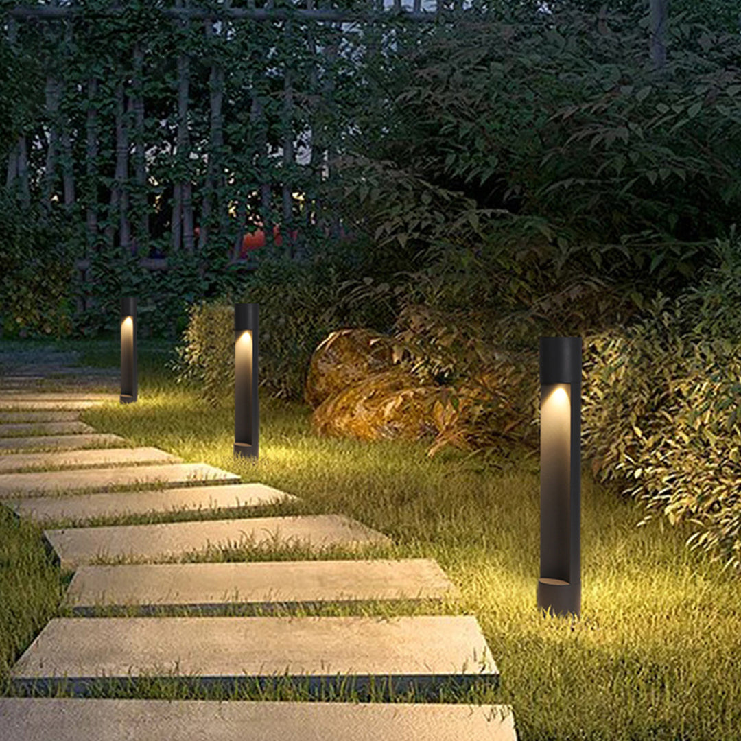 Garden walkway with evenly spaced sconce outdoor lighting posts producing soft ambient landscape light.