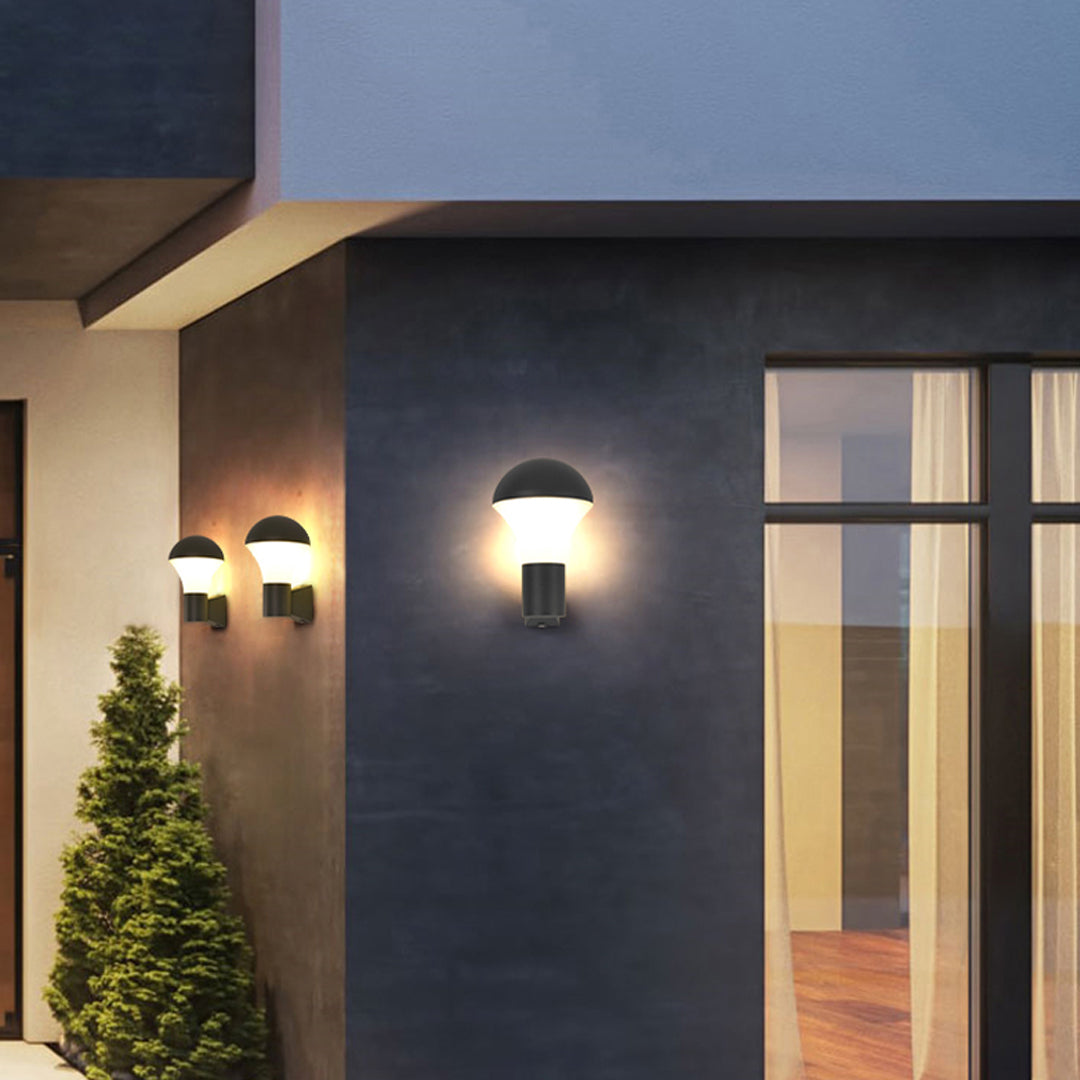 Minimal exterior façade featuring a single modern sconce outdoor lighting fixture casting warm light.