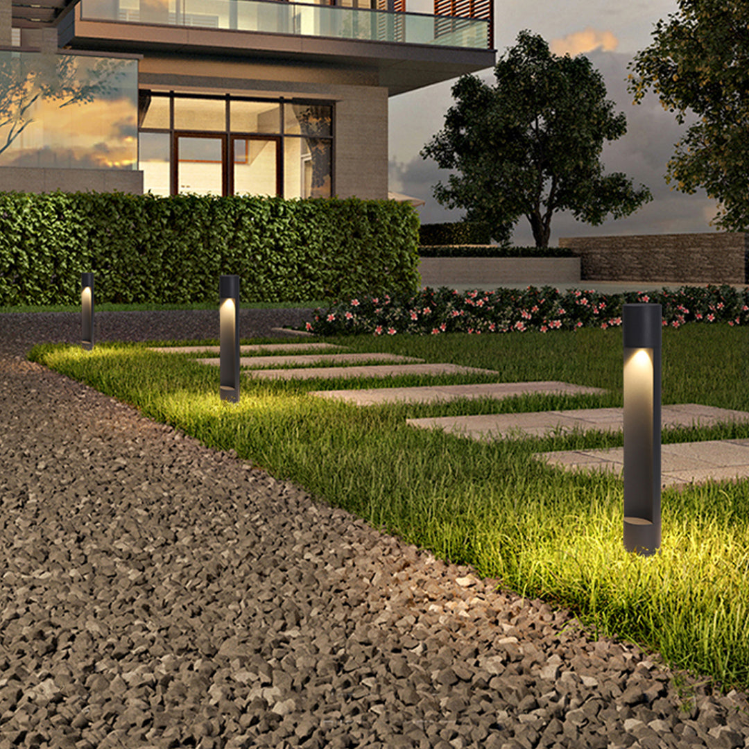 Outdoor gravel path highlighted by contemporary sconce outdoor lighting fixtures providing warm and focused light.
