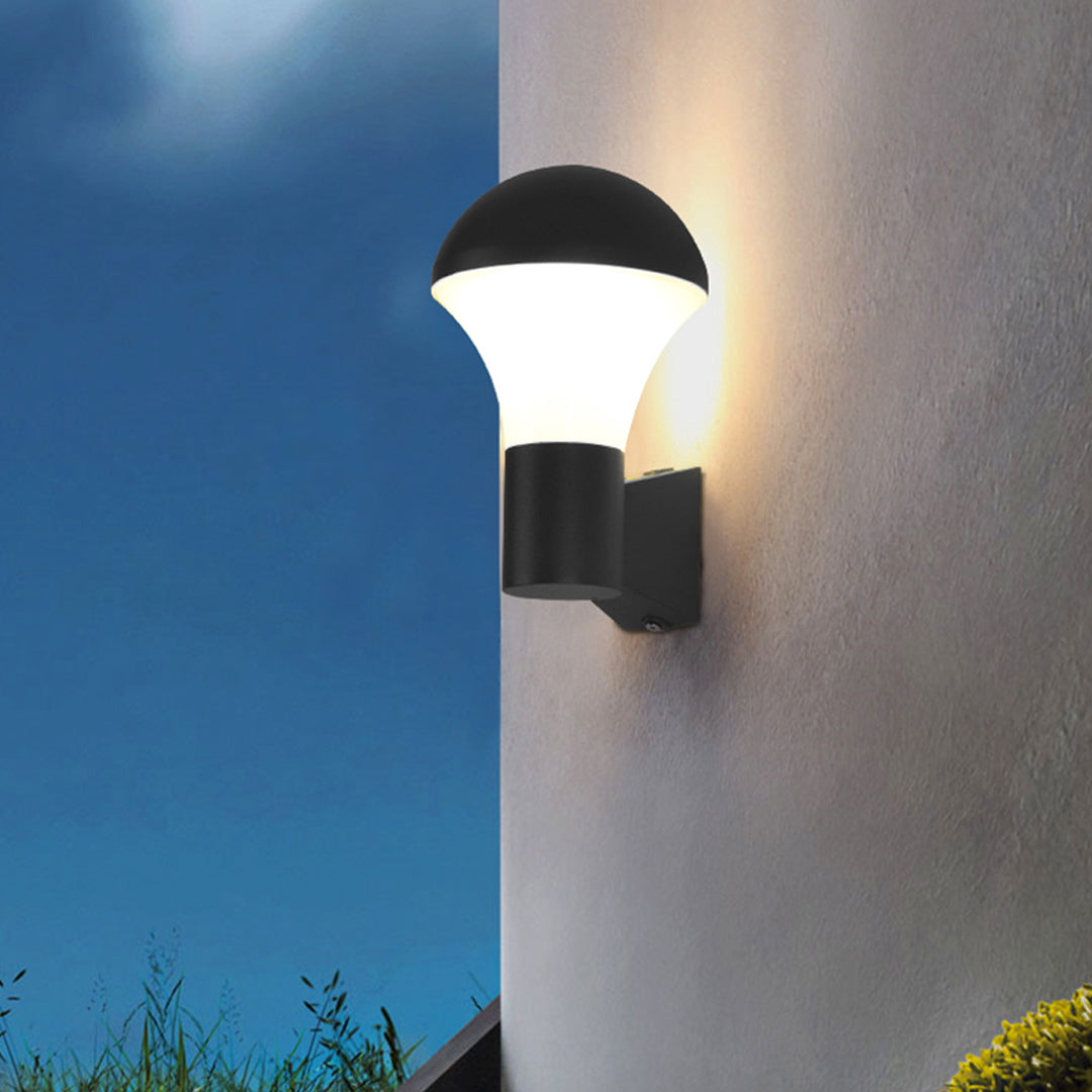 Nighttime outdoor wall with semi-dome sconce outdoor lighting creating smooth upward and downward glow.
