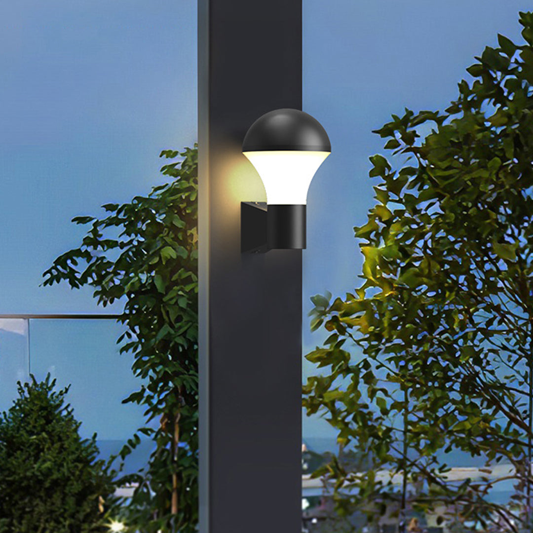 Outdoor pathway illuminated by contemporary sconce outdoor lighting fixture mounted on a dark post.