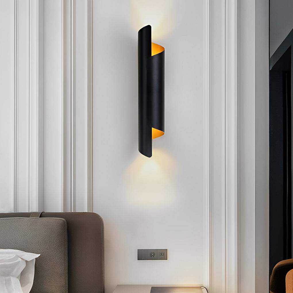 Scroll wall sconce with a black frame and gold accents, illuminating a cozy reading nook.