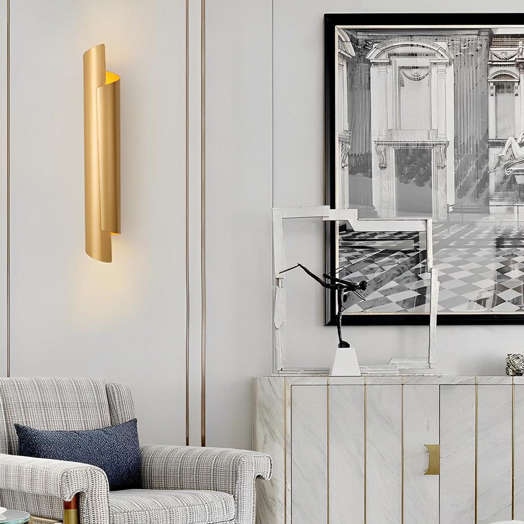 Scroll wall sconce in gold, providing ambient light in a modern bedroom with a tufted headboard.