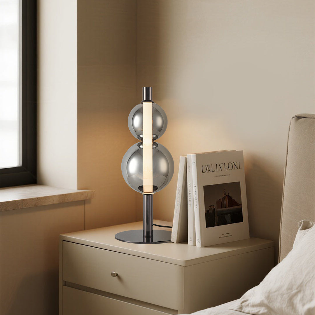 Sculptural art table lamp with chrome spherical design creating modern ambient lighting in bedroom