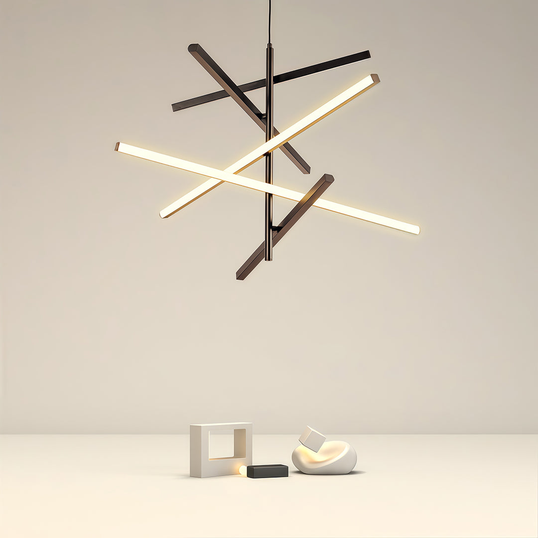 Sculptural iron linear chandelier with angular branches suspended above minimalist grey sofa.