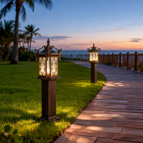 Bronze landscape post lights lining seaside path, creating elegant evening illumination.