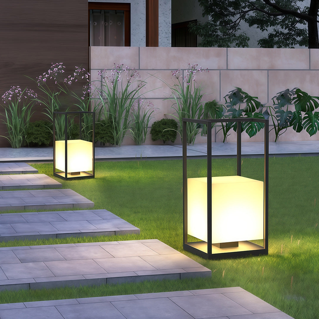 Contemporary outdoor lanterns with a black frame, installed near a seating area for ambient lighting.