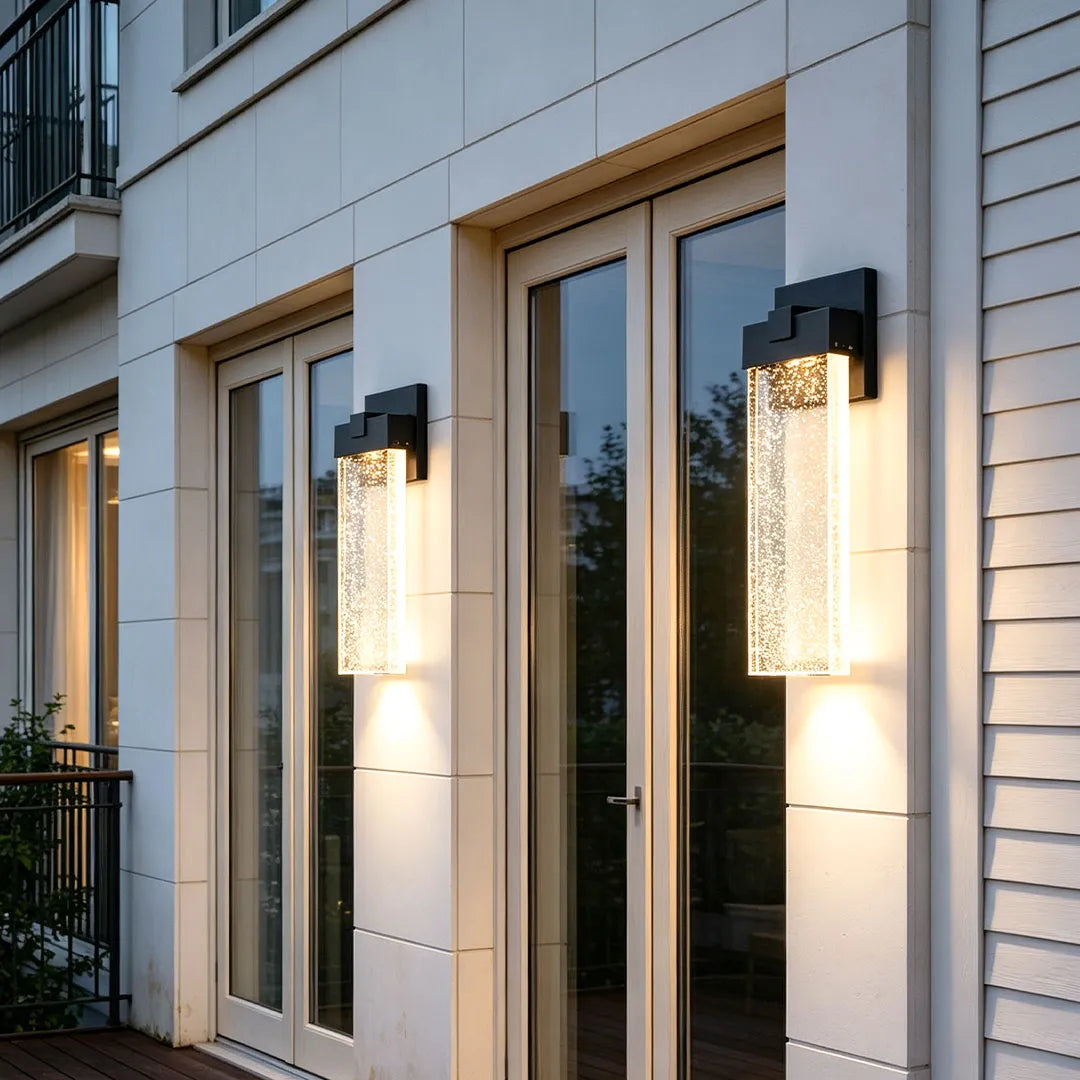 Seeded glass outdoor wall lighting mounted beside glass doors with elegant vertical design and soft ambient light.