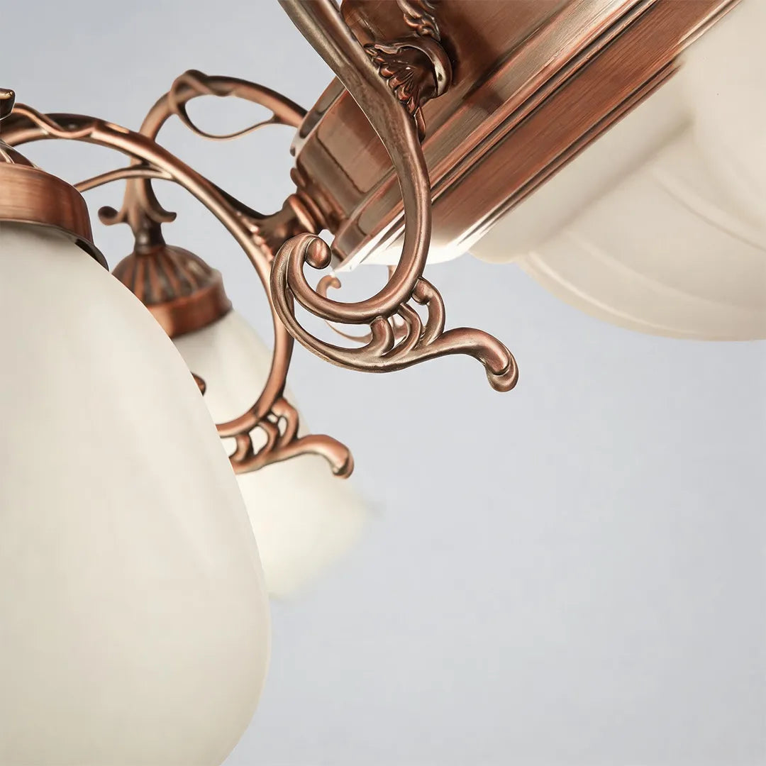 Close-up of a semi flush glass ceiling light featuring curved decorative arms and frosted tulip glass shades.