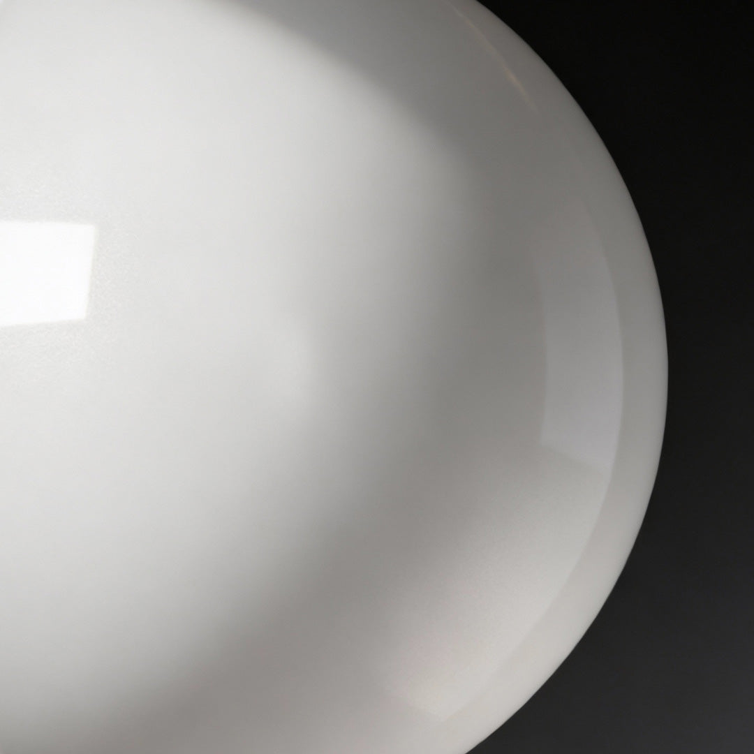 Close-up of semi-spherical outdoor lighting wall mounted fixture showcasing smooth surface and soft light diffusion.