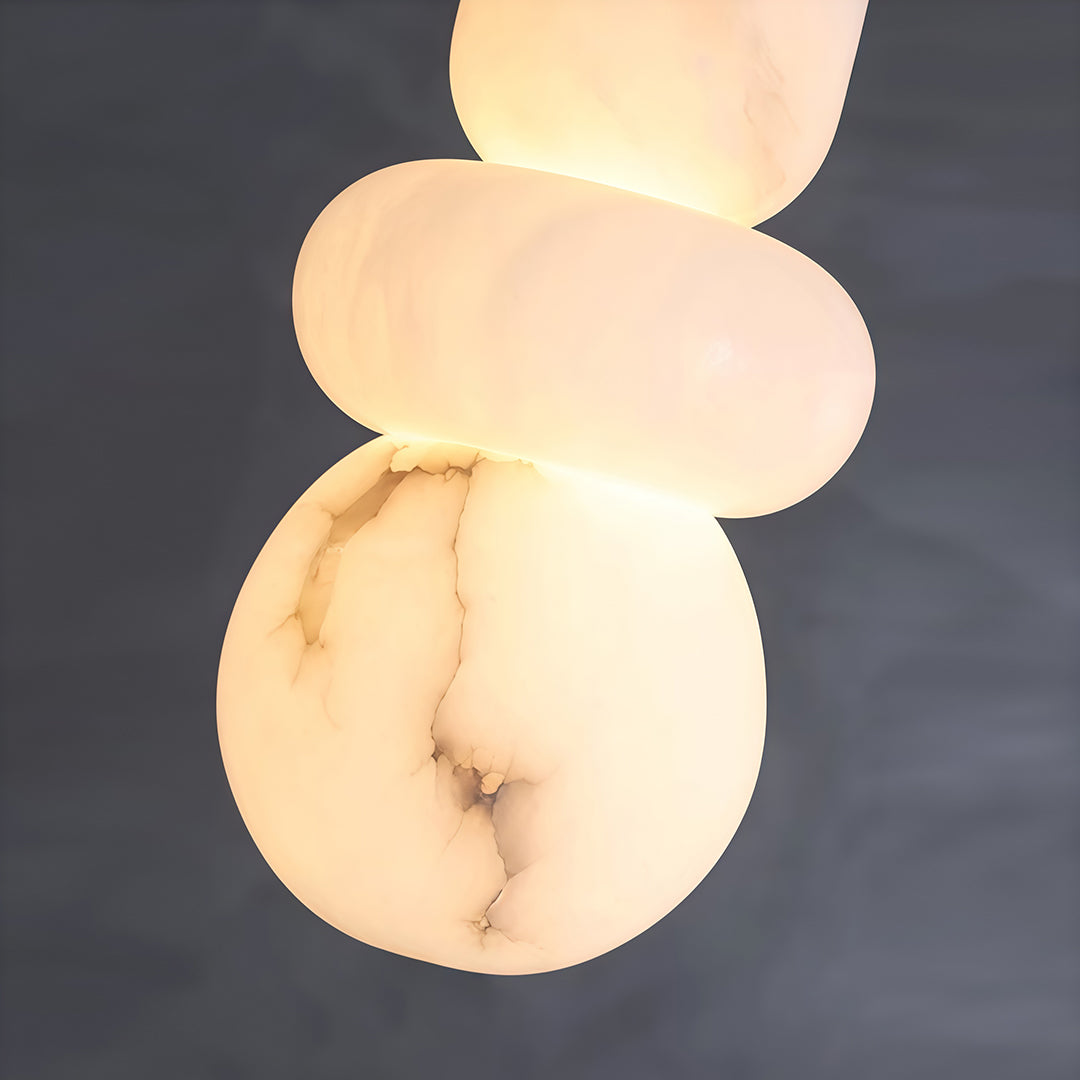 Serene minimalist pendant light featuring glass shade chandelier design illuminating modern bedroom with white tufted headboard.