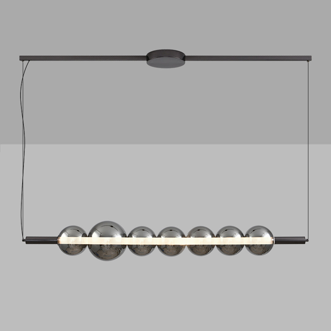 Modern silver pendant light for kitchen island with seven clear globe shades suspended on black linear track
