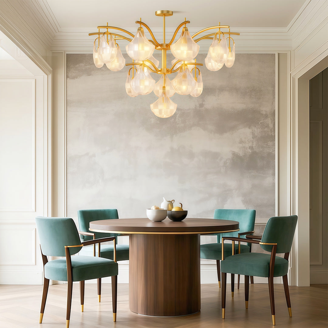 Modern luxury shell chandelier light above round dining table with teal chairs and natural light.