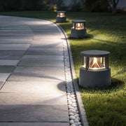 Short bollard light illuminating a modern garden pathway with warm ambient glow.