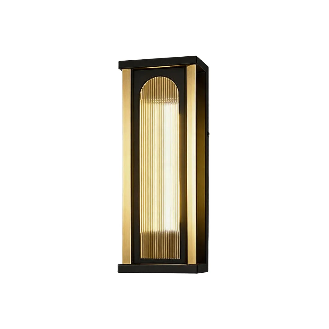Short outdoor wall sconce with black frame ribbed glass and warm LED lighting