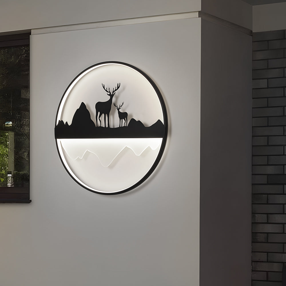 Silhouette wall light illuminating a garden pathway with deer and mountain silhouette.