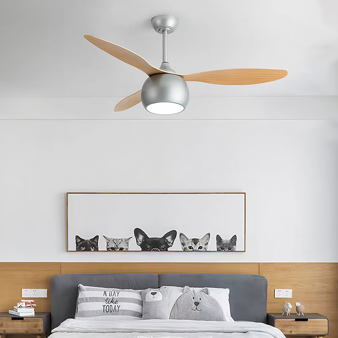Silver ceiling fan with light providing illumination above bedroom with gray bedding and wooden nightstands