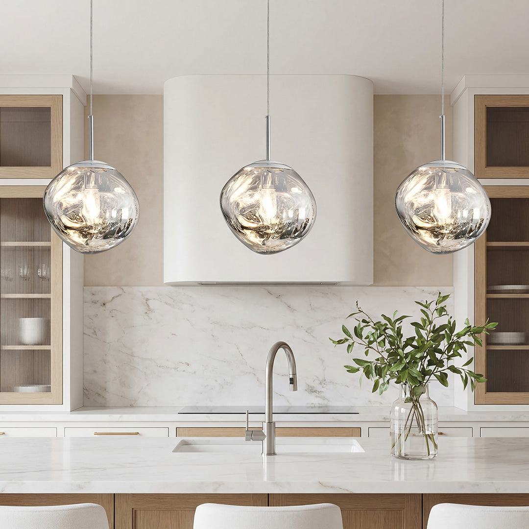 Elegant silver melt led pendant light trio over a modern marble kitchen island in bright room.