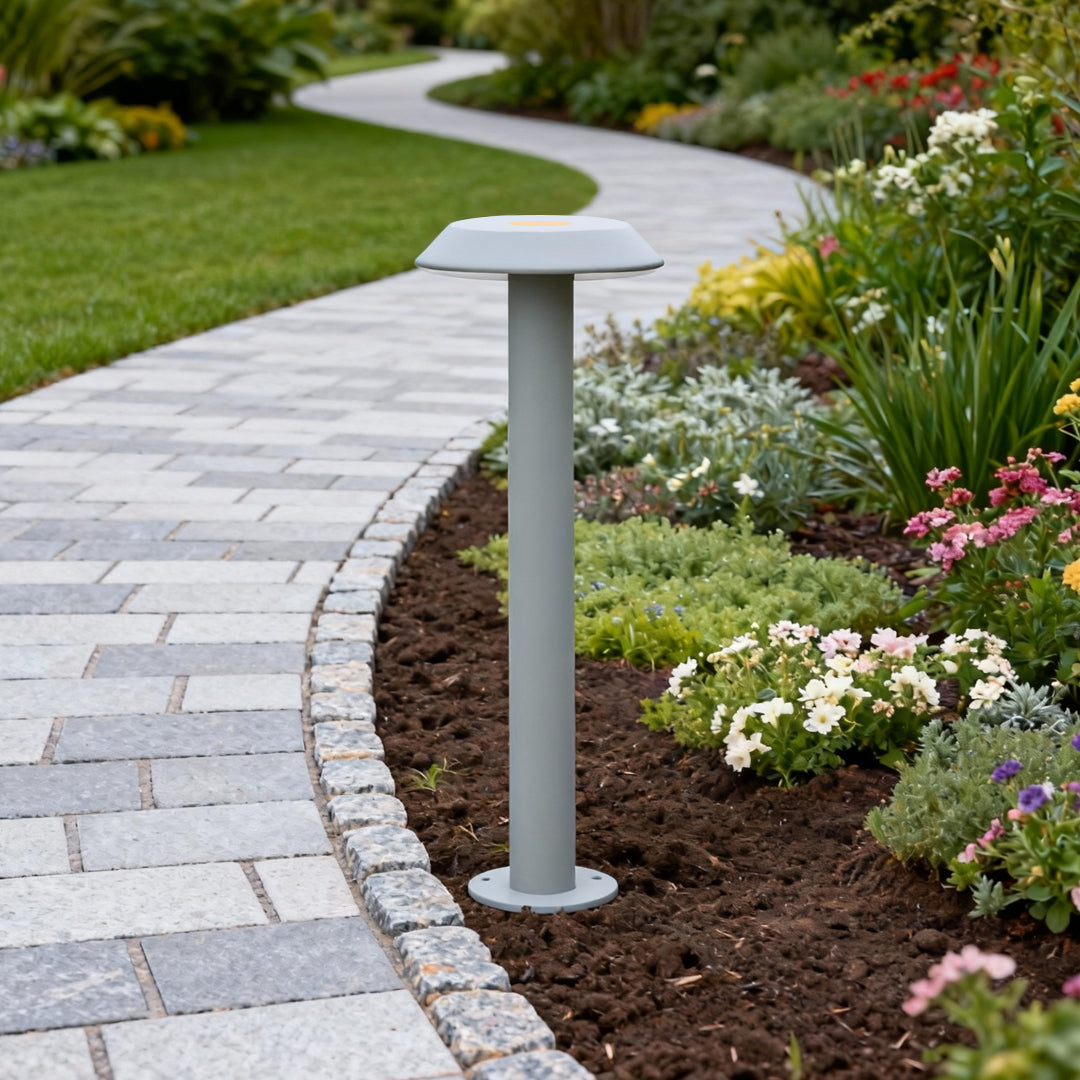 Silver path lighting LED installed along a bright residential walkway bordered by garden mulch.