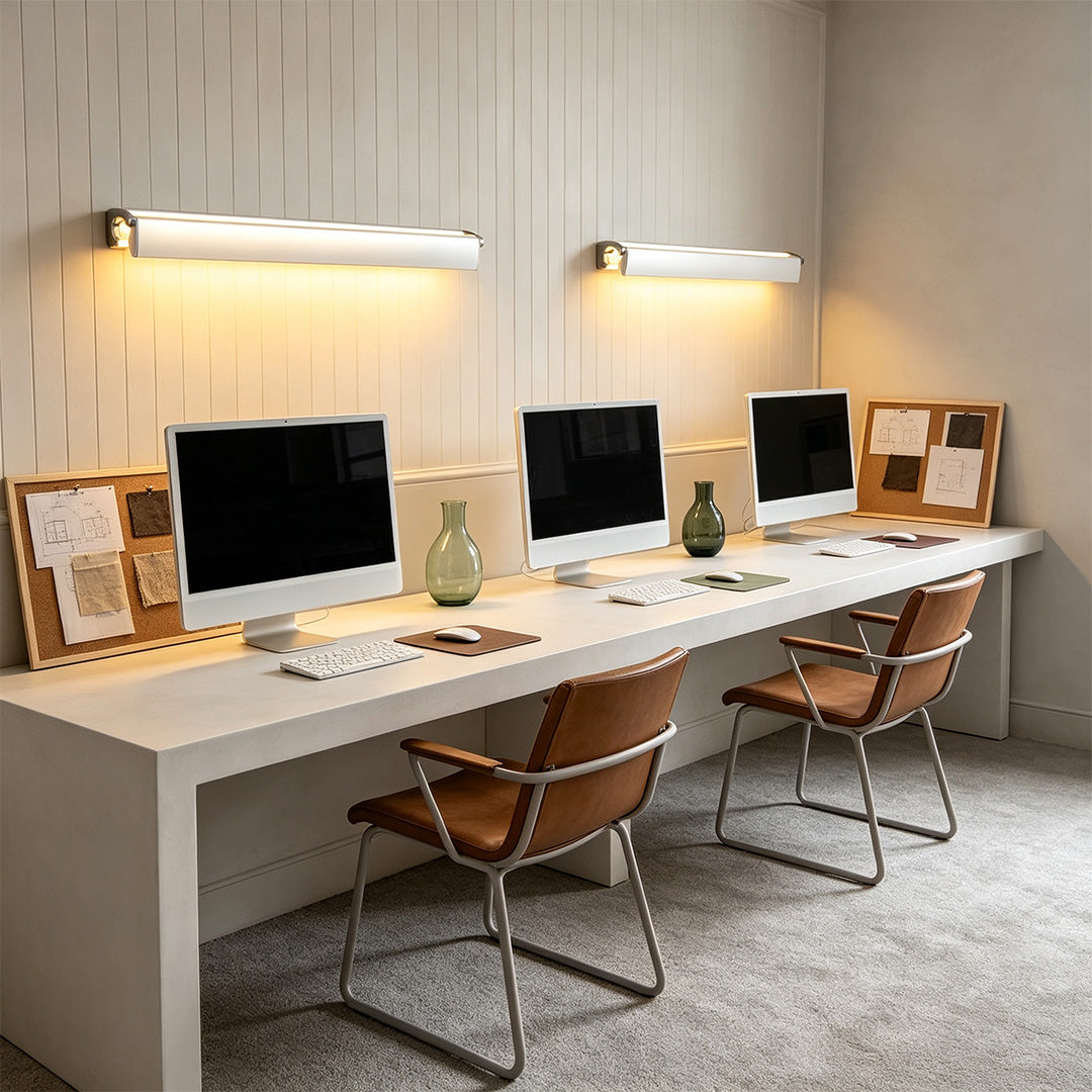 Contemporary silver wall lights mounted above office workstations with sleek linear LED design and warm glow.