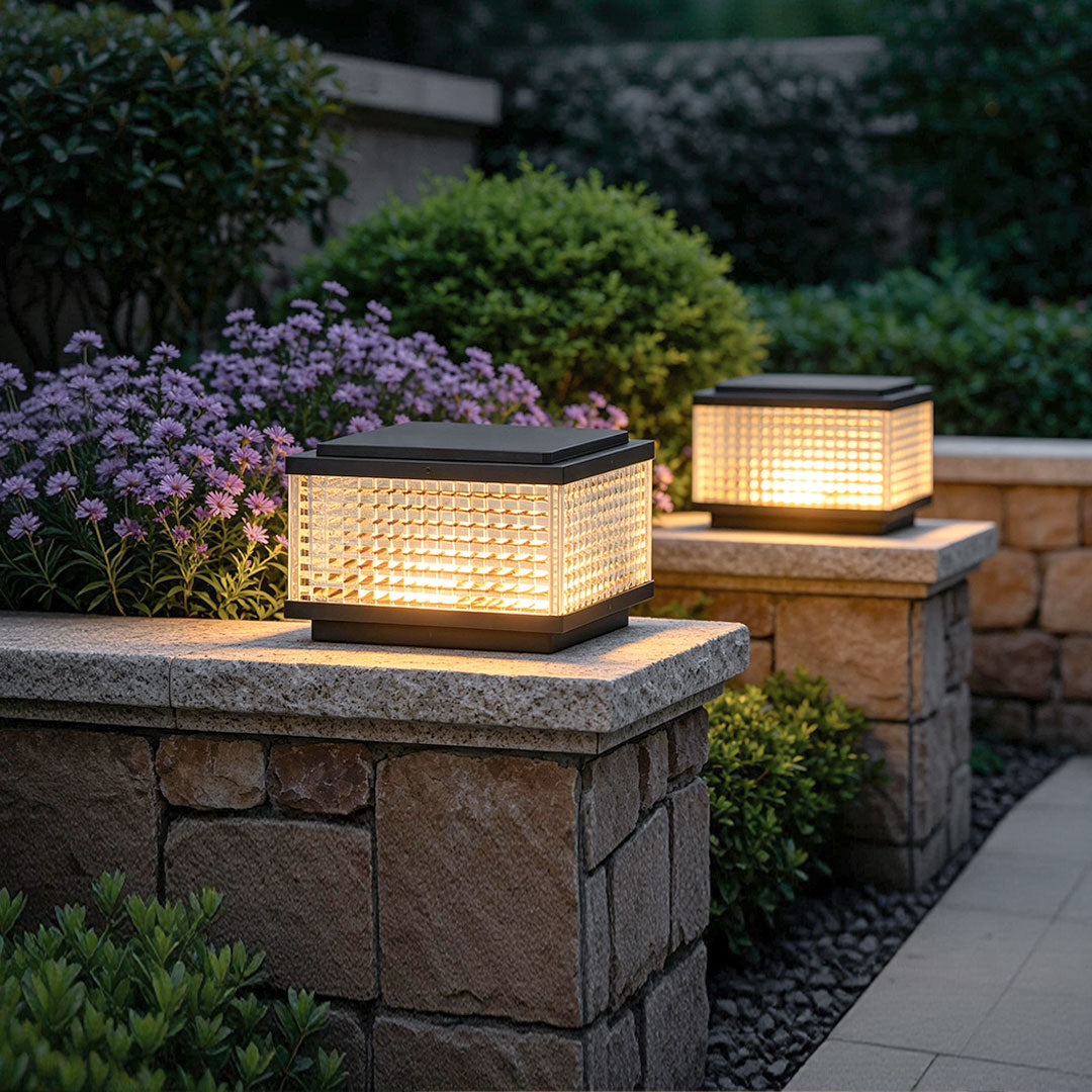 Modern large outdoor solar pillar lights installed on stone garden walls with warm ambient landscape lighting.