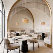 Elegant stainless steel pendant light fixtures illuminating a luxury restaurant with arched ceilings and warm ambiance.