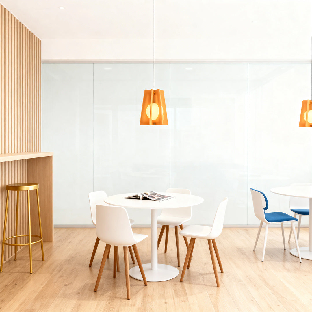 Simple amber felt fun pendant lights suspended over a white, minimalist table in a contemporary glass-walled office setting. 