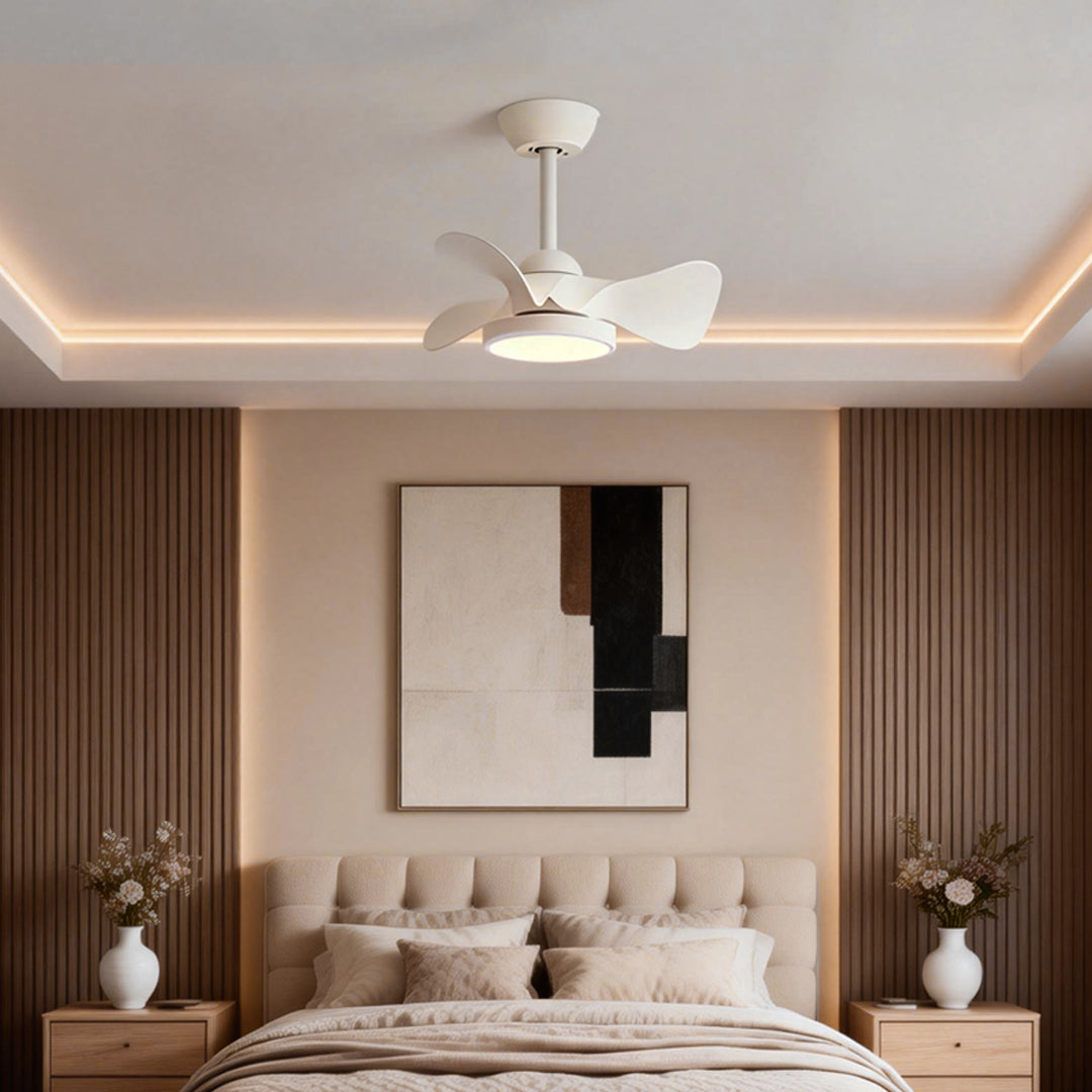 Simple white ceiling fan with light centered above a cozy bed, blending seamlessly with warm wood accents and neutral décor.