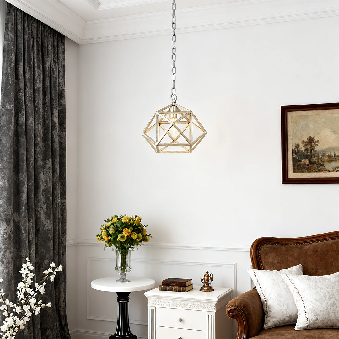Single gold metal pendant light providing accent illumination next to a sunflower bouquet in a traditional living room setting.