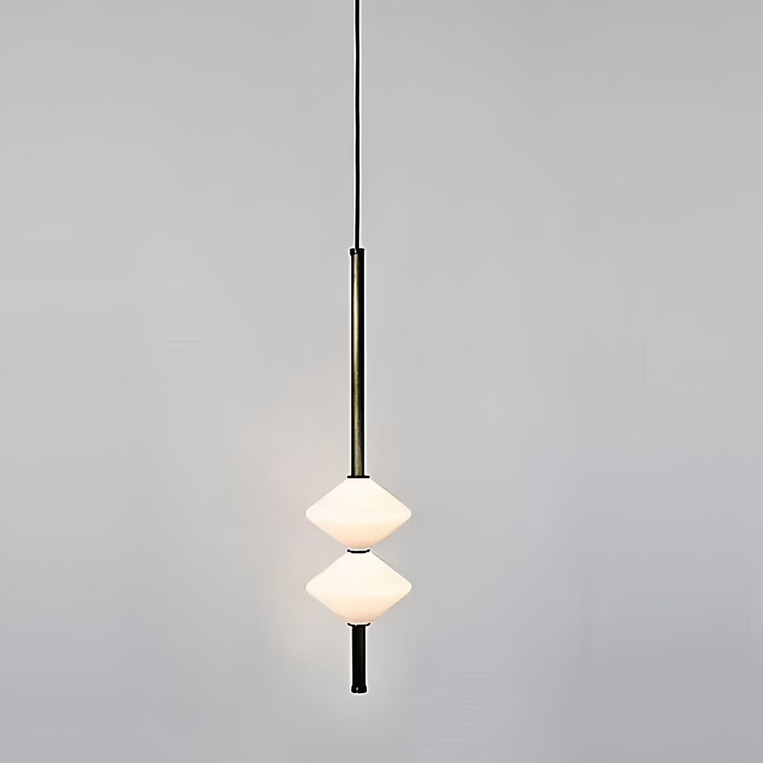 Designer bedside pendant light with tiered white shade hanging in minimalist interior space