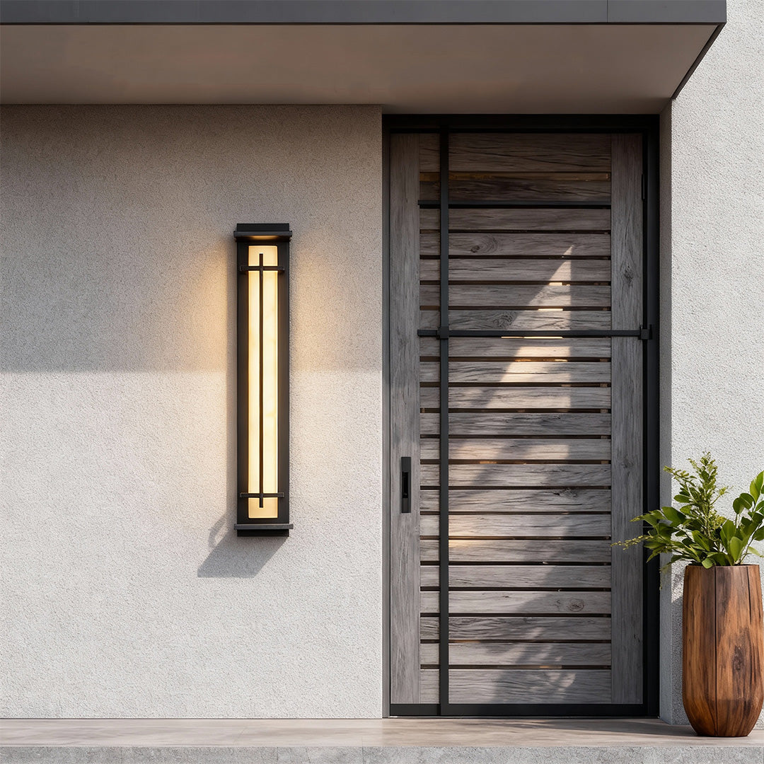 Single black outside wall lights providing accent illumination next to a modern wooden door.