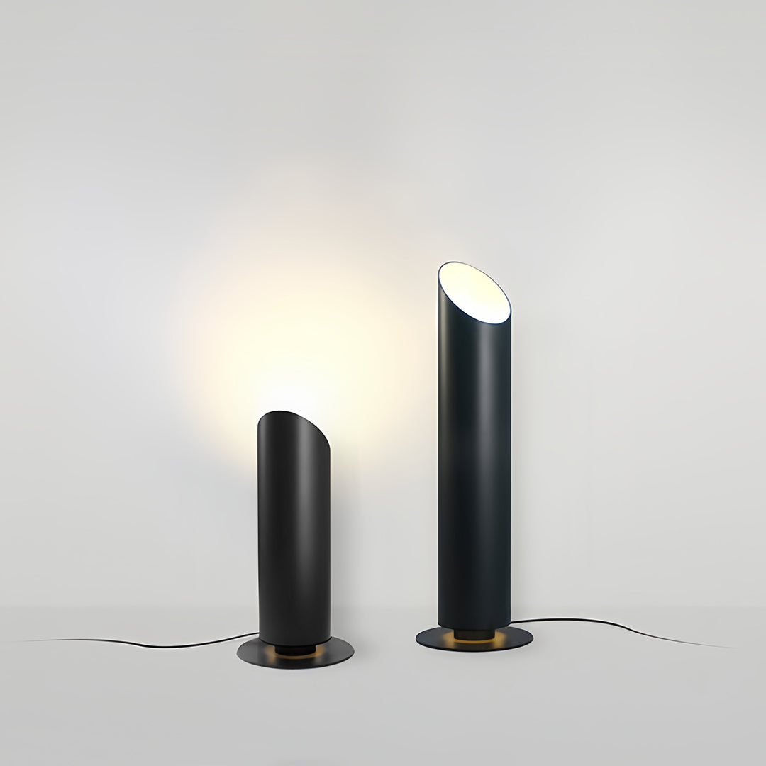 Close-up of a single landscape tree up lighting bollard installed among dense green foliage and small white flowers.