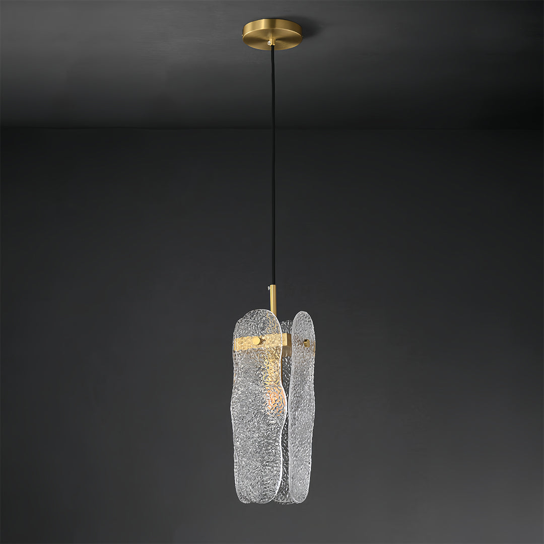 Single brass glass pendant light showcasing organic textured glass on black backdrop.