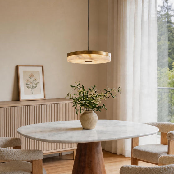 Single disc pendant light glowing above a round marble dining table in a serene modern room ok.