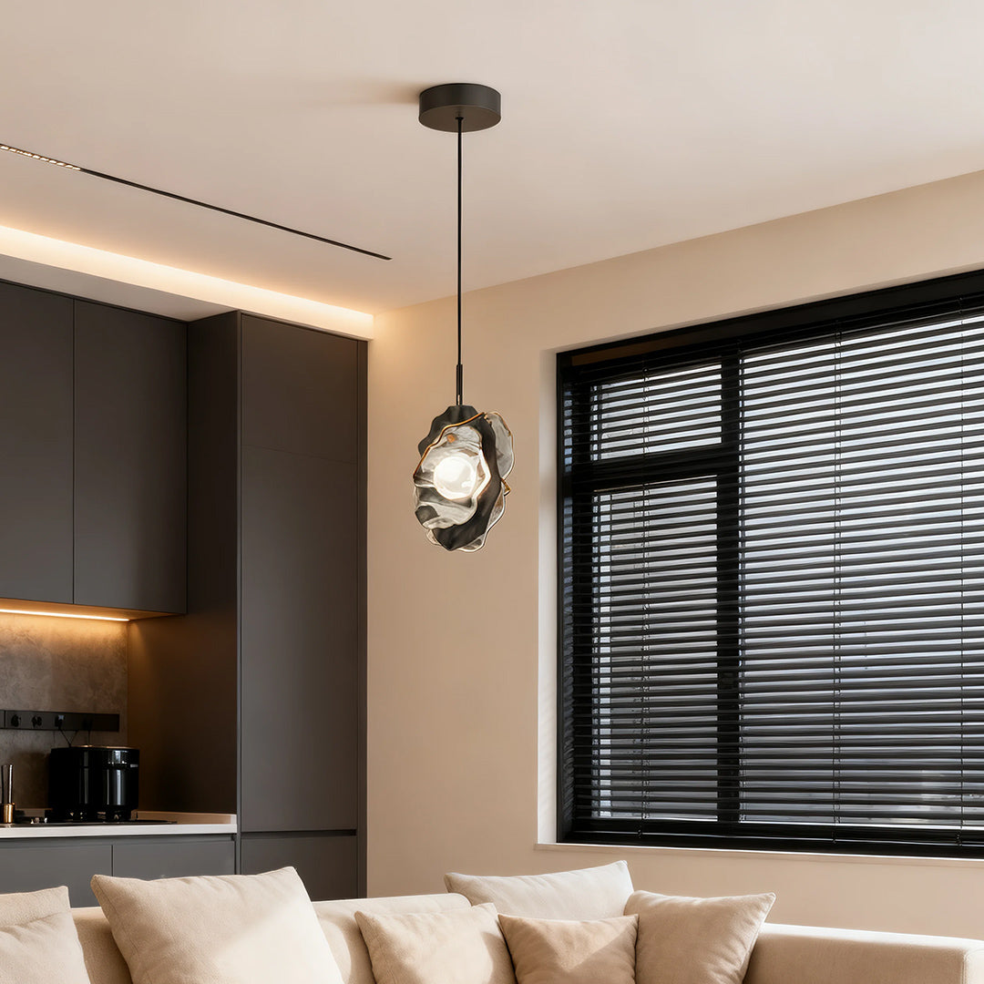 Single fun pendant light providing warm illumination in modern kitchen with beige tones and blinds