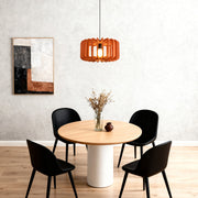 Single orange wooden slat Nordic pendant light fixture over a minimalist dining table 