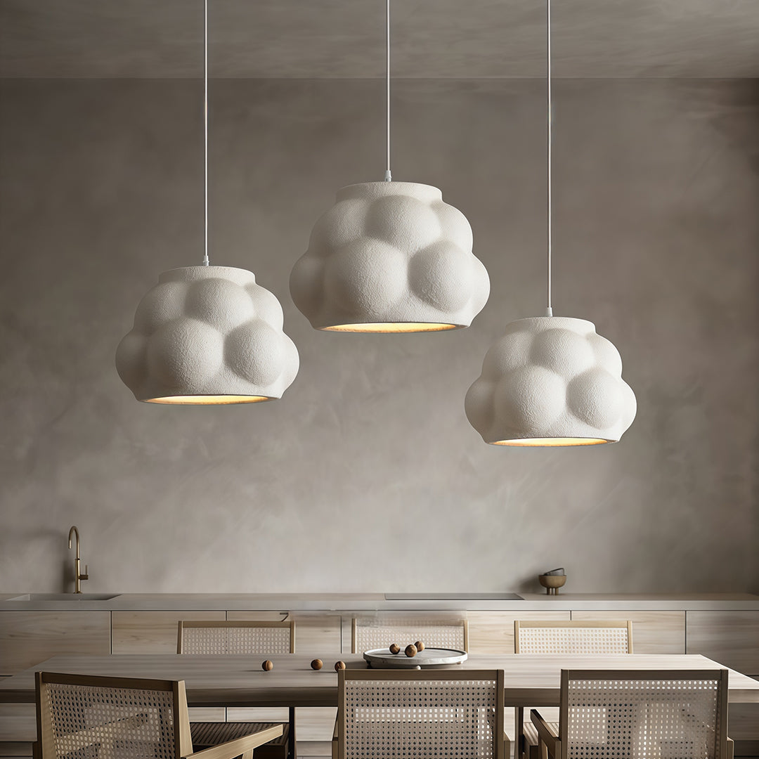 Set of white Single Pendant Light Fixtures hanging above dining tables in elegant modern restaurant.