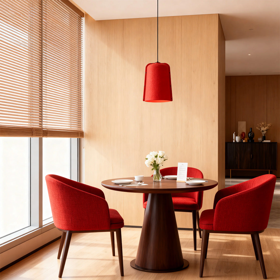 Single red adjustable pendant light fixture hanging over a small round dining table in a modern wood-paneled room.