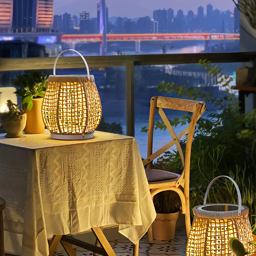 Single woven outdoor lanterns with a rope handle, providing soft illumination on a small outdoor dining table overlooking a city skyline.