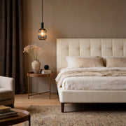 Single vintage glass pendant light hanging as a bedside lamp in a cozy modern beige bedroom.