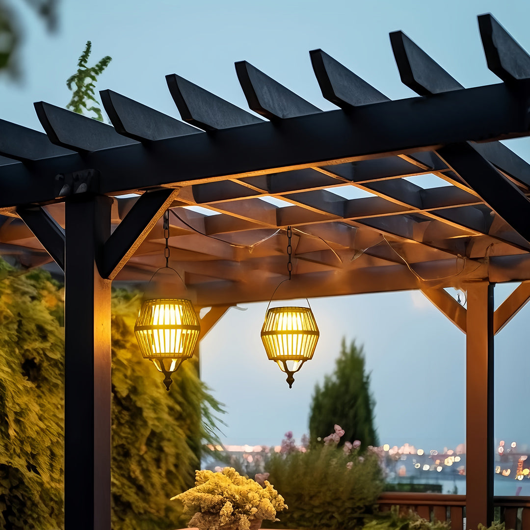Single japanese lantern pendant light hanging from a dark wooden pergola structure, providing evening outdoor illumination.